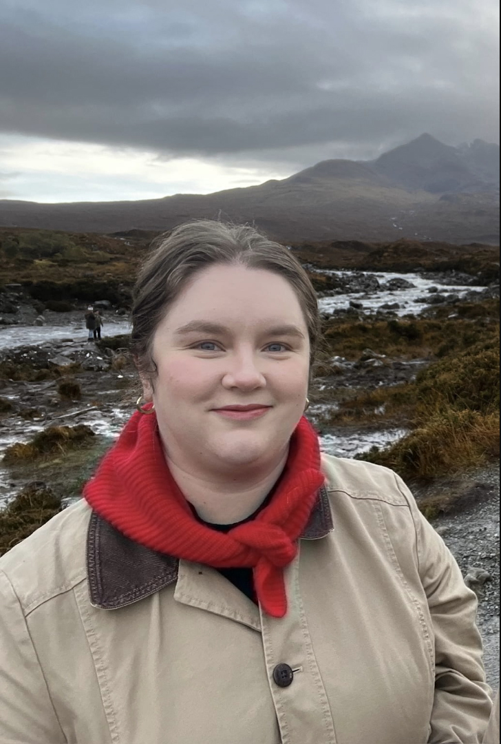 a young woman with a red scarf on in a Scottish landscape.